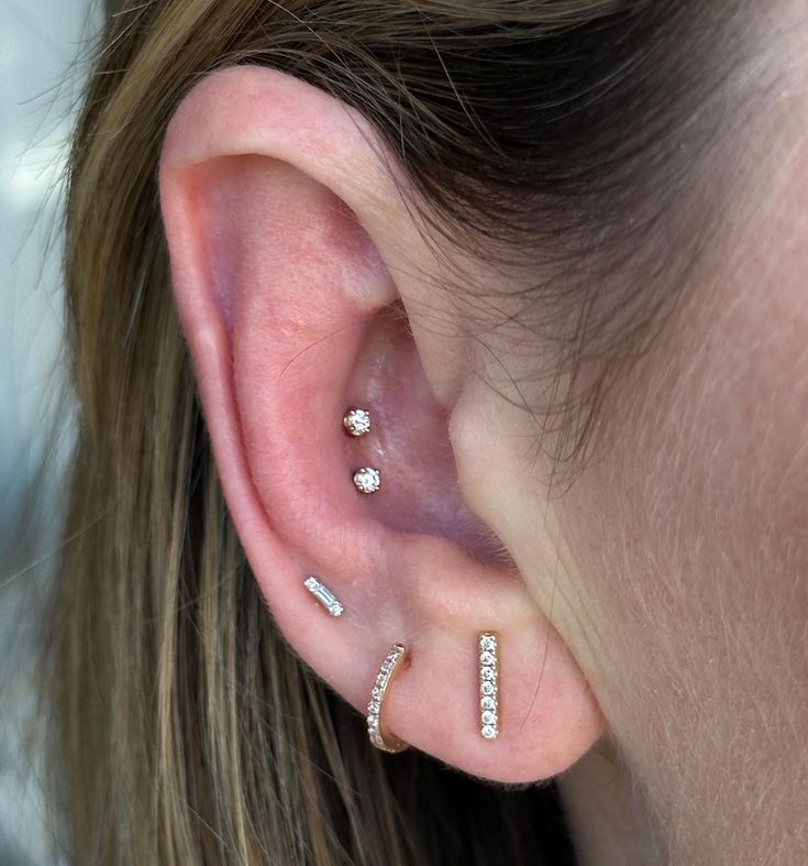 a close up of a person's ear with two different piercings on it