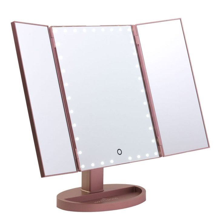 a pink lighted vanity mirror sitting on top of a table