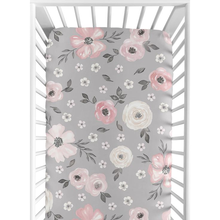 a gray crib with pink and white flowers on it