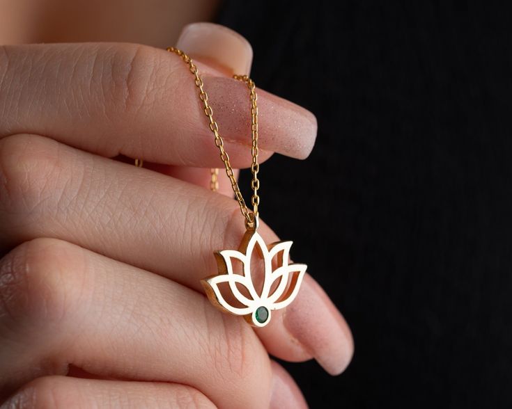 Elevate your style and spirituality with our Handmade Gold Lotus Necklace featuring a custom birthstone--a unique blend of personalized elegance and meaningful symbolism. Crafted with meticulous care, this exquisite piece is available in two exceptional materials: 925 sterling silver and 14K solid gold. Choose between the timeless allure of silver and the enduring warmth of gold, knowing that both options are of the highest quality. While the material is a significant choice, the true essence of this necklace lies in the delicate lotus pendant adorned with a custom birthstone. The lotus, a symbol of purity and enlightenment, is a captivating representation of beauty emerging from the depths. The added personal touch of a custom birthstone enhances the necklace's significance, making it a p Symbolic May Birthstone Jewelry As Gift, Spiritual 14k Gold Gemstone Jewelry, Spiritual Gold Birthstone Jewelry, Symbolic Green Gemstone Jewelry, Spiritual White Gold Necklace With Birthstone, Spiritual Birthstone Pendant Jewelry, Spiritual 14k Gold Jewelry For Gifts, Symbolic Rose Gold Jewelry Gift, Spiritual 14k Gold Birthstone Jewelry