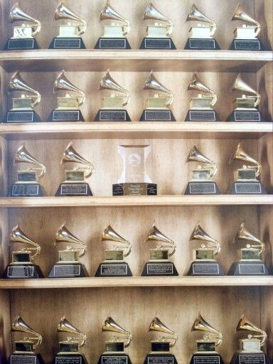 many awards are lined up on wooden shelves