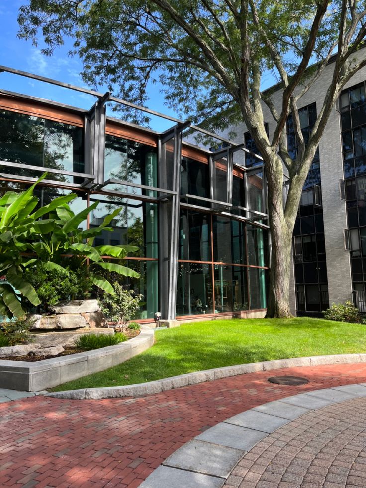 the building has many windows and plants in front of it