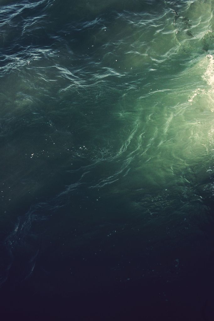 a person riding a surfboard on top of a large body of water in the ocean