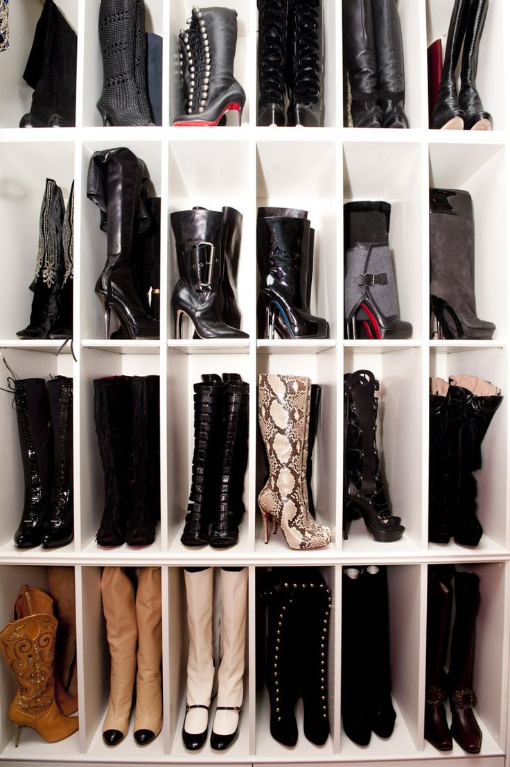 a white shelf filled with lots of different types of boots