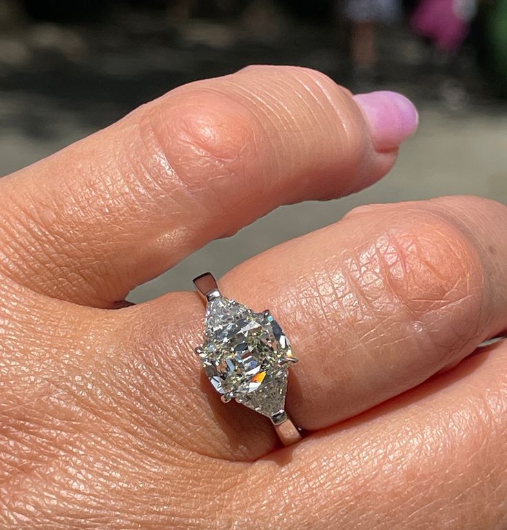 a woman's hand with a diamond ring on it