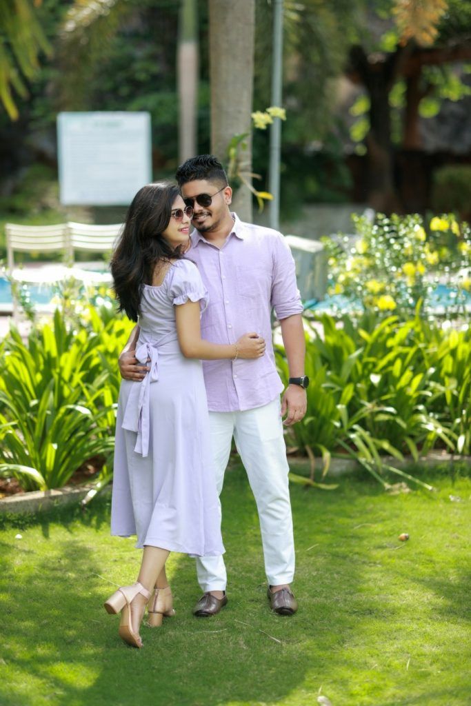 a man and woman standing next to each other in the grass