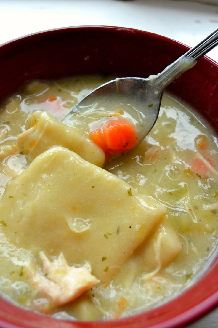 a red bowl filled with soup and a spoon