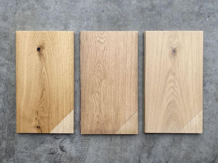 three pieces of wood sitting on top of a cement floor next to each other,