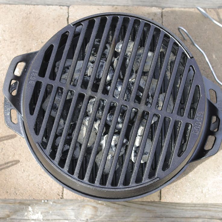 an outdoor grill is shown with rocks in the center and wire attached to it's sides