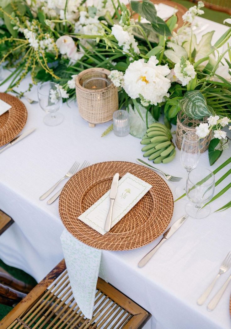 the table is set with place settings and flowers