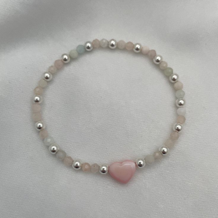 Introducing our Blush Heart and Gemstone Bead Bracelet in radiant sterling silver—a true embodiment of joy and elegance! With its delicate blush heart charm and shimmering gemstone beads, this bracelet is a celebration of love and individuality. Each bead tells a story, reflecting the wearer's unique journey and personality. Whether you're adding a pop of color to your everyday look or stacking it with other treasures, this bracelet is sure to spark joy and conversation wherever you go. Embrace Puffy Heart Charms, Spark Joy, Gemstone Beaded Bracelets, Puffy Heart, Pink Beads, Pink Bracelet, Matching Bracelets, Pink Opal, Initial Charm