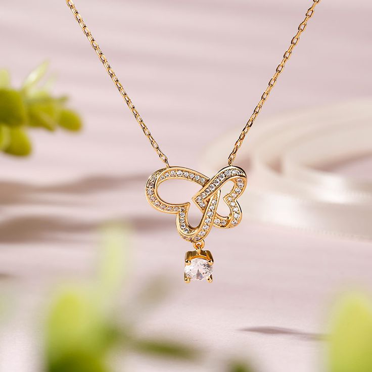 Delicate and charming, this interlocked heart necklace makes an adorable gift for your loved one. Heart is one of the most popular motifs in jewelry. It's always related to love. Beautifully handcrafted in sterling silver, this necklace showcases a round-cut shimmering stone hangs under the interlocked heart, adding sparkle to the design. The interlocked heart is set with shimmering stones. Treat yourself or surprise her with this lovely piece.Carat Weight: 0.9 ctStone Size: 5 mmStone Type: Jeul Cubic Zirconia Necklace For Mother's Day, Mother's Day Cubic Zirconia Necklace Gift For Her, Mother's Day Gift Cubic Zirconia Necklace, Cubic Zirconia Jewelry For Mom, Valentine's Day Clavicle Chain With Heart Pendant, Valentine's Day Heart Pendant Clavicle Chain, Dainty Double Heart Cubic Zirconia Jewelry, Fine Jewelry Double Heart Cubic Zirconia Necklace, Fine Jewelry Double Heart Necklace With Cubic Zirconia