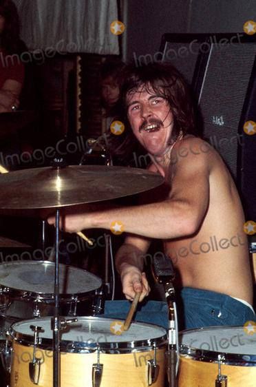 a man with no shirt on playing drums