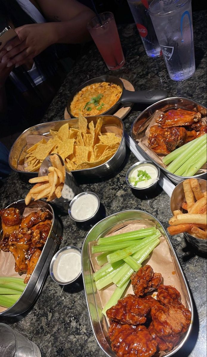 several trays filled with different types of food on top of a marble countertop