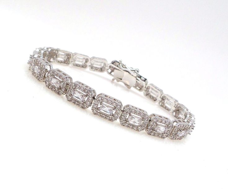 magnificent Cubic Zirconia Wedding Bracelet starring rectangle halo Cut Cubic Zirconia with delicate CZ pave. Our bracelet is the perfect accessory for brides, bridesmaids, mothers of the bride and pageants. Each stone size: 11mm x .8mm. matching earrings available and sold separately. Diamond Tennis Bracelet For Wedding, Silver Tennis Bracelet With Emerald Cut Diamond Accents, Silver Emerald Cut Tennis Bracelet With Diamond Accents, Elegant Emerald Cut Diamond Bracelet For Wedding, Elegant Emerald-cut Diamond Wedding Bracelet, Silver Emerald Cut Diamond Bracelet For Wedding, Elegant Silver Emerald Cut Tennis Bracelet, Emerald Cut Cubic Zirconia Bracelets For Weddings, Elegant Emerald Cut Tennis Bracelet For Wedding