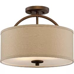 a light fixture with a beige shade on the drum and an iron frame around it