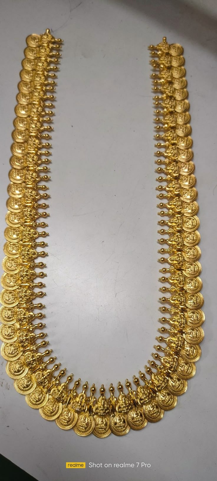 a gold necklace is displayed on a table