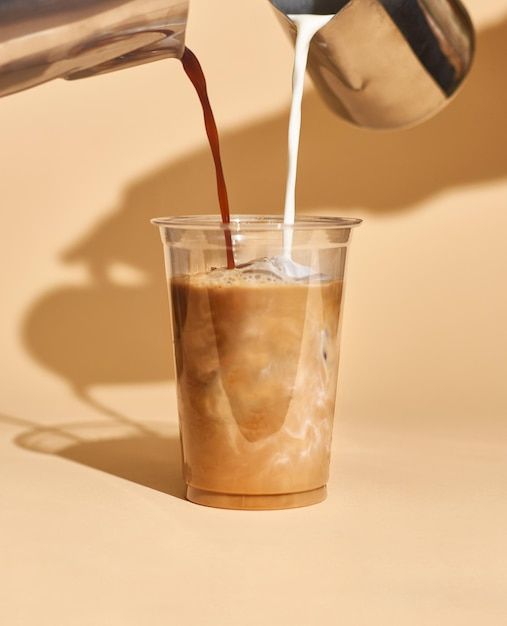 a person pours coffee into a glass