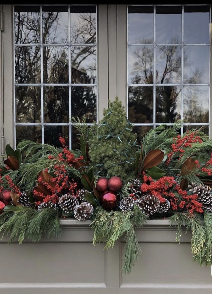 a window box filled with christmas decorations and greenery