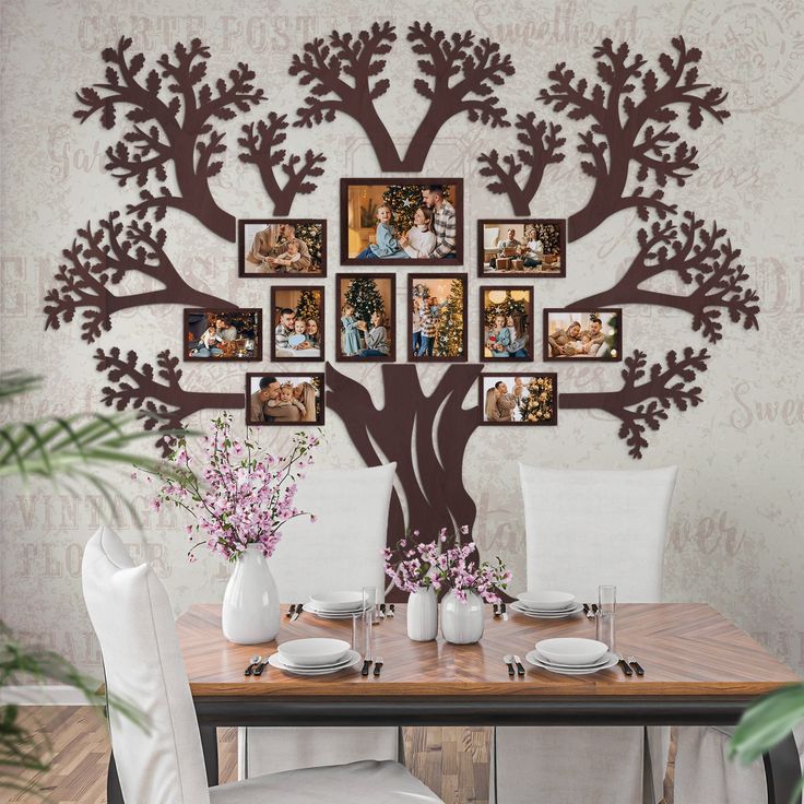 a dining room table with chairs and pictures on the wall above it, along with vases filled with flowers