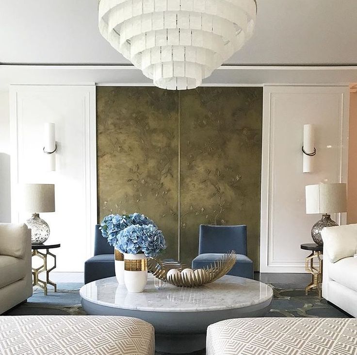 a living room filled with furniture and a chandelier hanging from the ceiling over a table