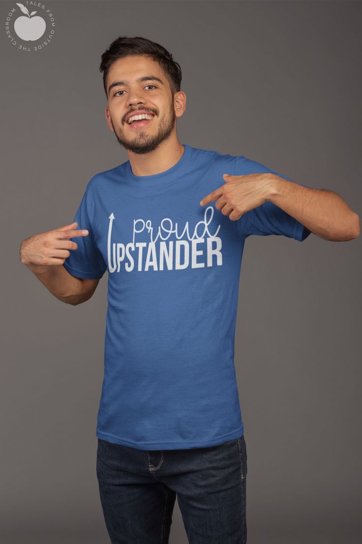 a man in a blue t - shirt is pointing to his right with one hand