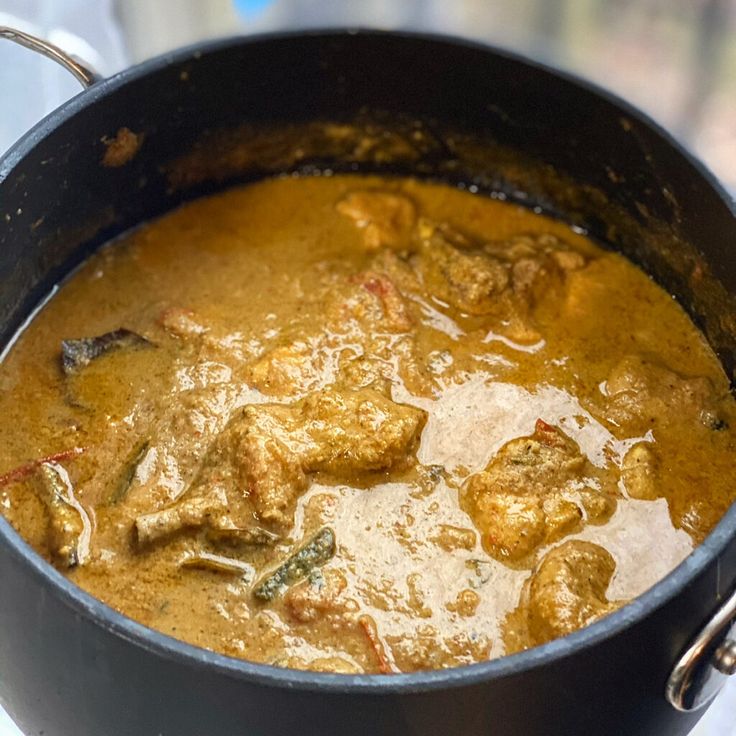 a pot filled with stew sitting on top of a stove