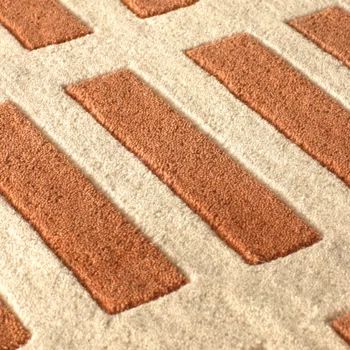 an orange and white area rug on the floor with several squares in it that have been placed together