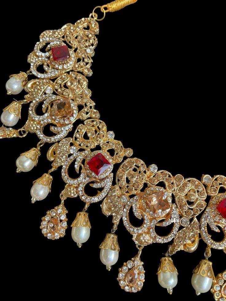 This set is the most in demand set for the upcoming wedding and festive season! The bright hues and the beautiful fit will go perfectly with any outfit and the neutral finish with gold tones can be paired with different colors for a statement look. Perfect for bridal or semi bridal wear Necklace comes with matching earrings, jhumar and tikka. Comes in 2 different colors Gold Traditional Party Wear For Eid, Elegant Semi-stitched Anarkali Set With Stone Work, Gold Sets For Festivals Party Wear, Gold Party Wear Sets For Festivals, Gold Party Wear Dupatta For Festive Occasion, Wedding Sets With Stone Work For Diwali, Elegant Sharara With Stone Work For Festive Occasions, Festive Lehenga With Intricate Design For Diwali, Elegant Red Traditional Wear