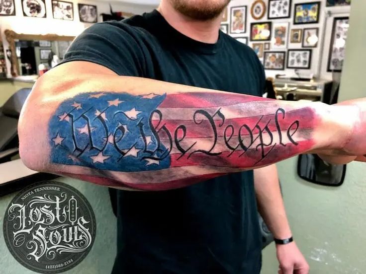 a man with a tattoo on his arm that reads we the people and has an american flag painted on it