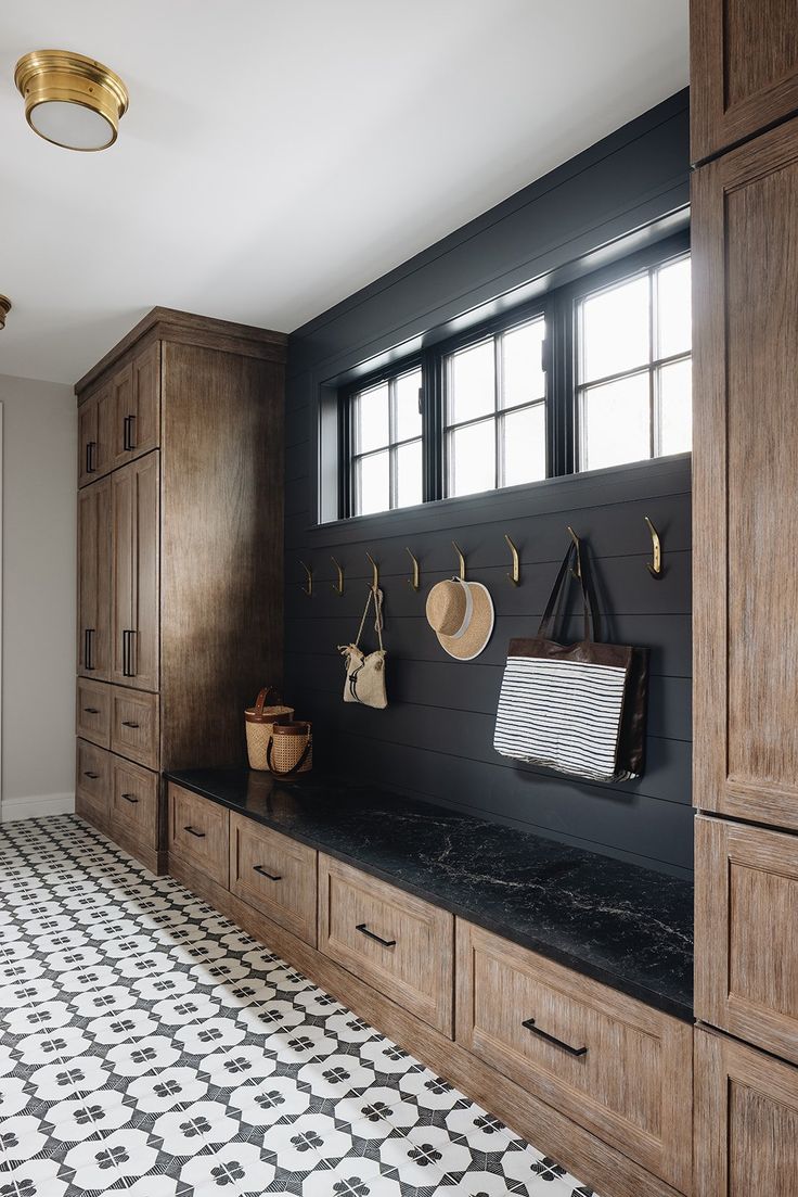 a black and white tiled floor in a room with wooden cabinets, hanging utensils and other items