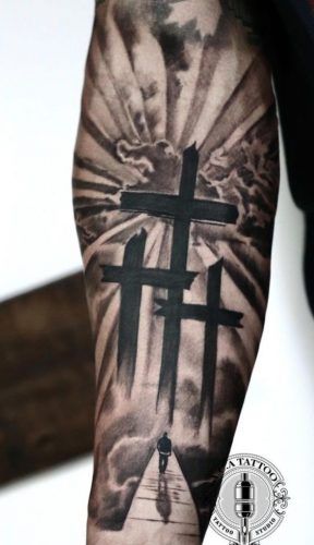 a man with a cross tattoo on his arm