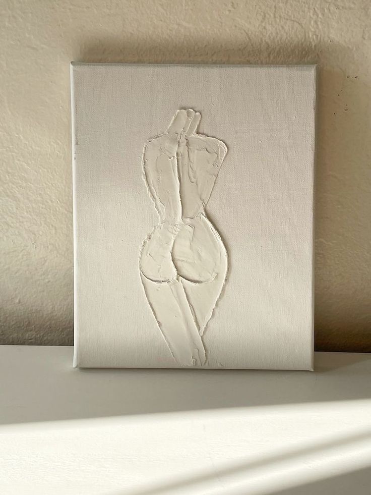 a white painting with a woman's body on it