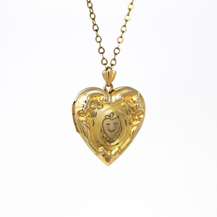 Pretty vintage circa 1940s era 10k gold filled letter "U" locket! This lovely pendant has a heart shape with floral designs on the front, and a letter "U" engraved in the center. The piece is shown modeled on a vintage gold filled 19" chain. A wonderful piece of personalized keepsake jewelry!  ERA - Circa 1940s - Retro  METAL / MATERIAL - Gold filled pendant, gold filled chain, original paper inserts MARKINGS / HISTORY - Back of bail marked "1/20 10k G. Filled" CONDITION - Good vintage condition. Gold filled metal has been professionally polished & cleaned. Original paper inserts present along with 1 photo bezel. Very little appropriate patina & wear remains. Amazing vintage letter "U" locket!  SIZE / MEASUREMENTS - Chain Modeled: 19 inches, Pendant (including bail): 1  x 3/4 inches, Weigh Heirloom Locket Necklace For Valentine's Day Anniversary, Heirloom Heart Locket Necklace For Anniversary, Yellow Gold Locket Necklace With Vintage Charm For Anniversary, Vintage Jewelry For Valentine's Day, Vintage Locket Heart Necklace For Anniversary, Vintage Heart Pendant Locket Necklace For Wedding, Antique Heart Charm Locket Necklace For Anniversary, Antique Jewelry With Vintage Charm For Anniversary Gift, Vintage 14k Gold Locket Necklace