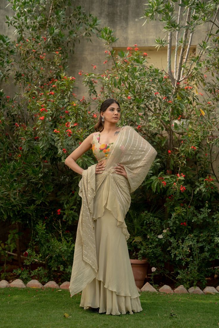 This beautiful saree is perfect for special occasions like weddings or festivals. Made from Chanderi silk georgette, it's lightweight and comfortable to wear. The beige color adds elegance, and the saree comes with a sleeveless blouse that has intricate heavy handwork prints, adding to its charm. Whether you're a mother, sister, wife, or bride, this saree is sure to make you stand out and feel special. Item - Saree Blouse Fabric - Chanderi Silk and Georgette Color - Biege Blouse Sleeve - Sleevel Traditional Sleeveless Chanderi Pre-draped Saree, Semi-stitched Sleeveless Pre-draped Saree With Cutdana, Sleeveless Georgette Traditional Wear For Wedding, Semi-stitched Sleeveless Georgette Pre-draped Saree, Sleeveless Chanderi Traditional Wear For Reception, Sleeveless Dresses With Cutdana For Reception, Elegant Sleeveless Georgette Traditional Wear, Pre-draped Zari Work Saree For Reception, Sleeveless Chanderi Pre-draped Saree For Festive Occasions