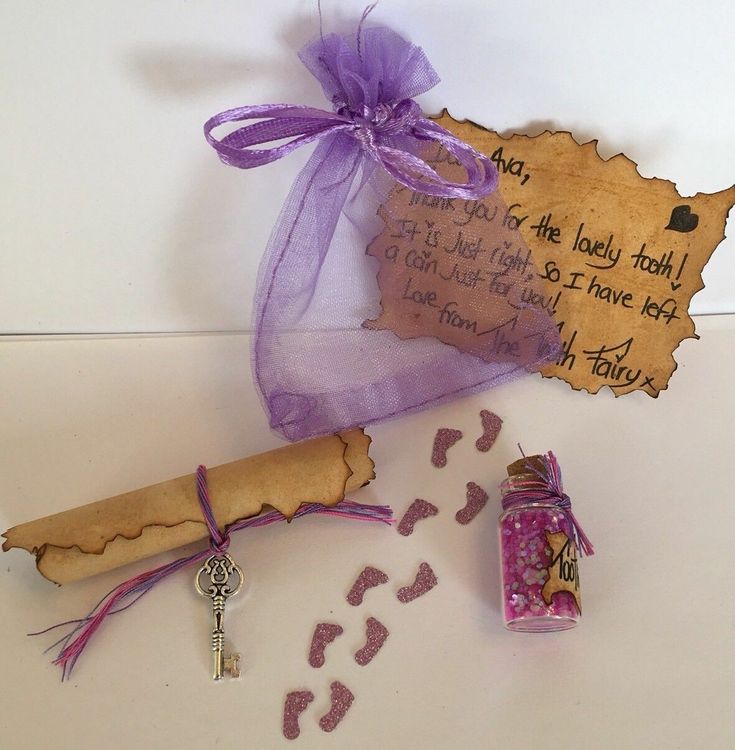 a bottle and cork with writing on it sitting next to a keychain that has a purple ribbon tied around it