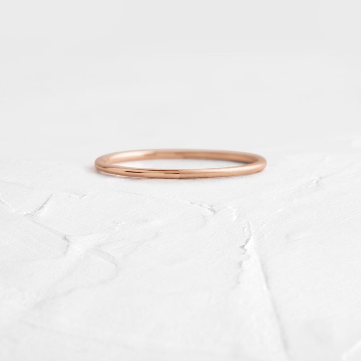 a gold ring sitting on top of a white surface