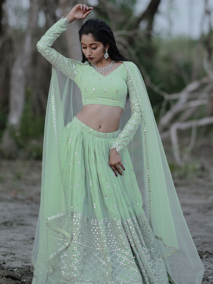 This exquisite ensemble exudes elegance and charm with its pastel green color and intricate detailing. Crafted from high-quality georgette fabric, the lehenga is adorned with zari embroidered and heavy sequin work, making it a perfect choice for weddings, receptions, engagements, and other special occasions.
The semi-stitched design allows for customization up to 42 inches, ensuring a perfect fit for every body type. The matching blouse, also made from georgette material with zari and sequin wor Green Georgette Sets With Intricate Embroidery, Green Lehenga With Intricate Embroidery In Georgette, Pista Green Georgette Lehenga With Traditional Drape, Pista Green Georgette Lehenga In Traditional Drape, Green Georgette Party Wear Sets, Green Georgette Lehenga With Sheer Dupatta, Pista Green Georgette Choli With Resham Embroidery, Green Dabka Work Lehenga For Reception, Green Lehenga With Dabka Work For Reception