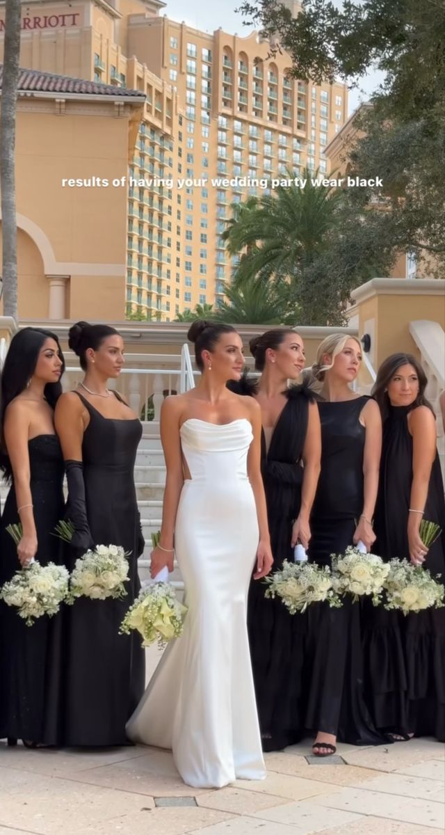 a group of women standing next to each other holding bouquets in front of a building