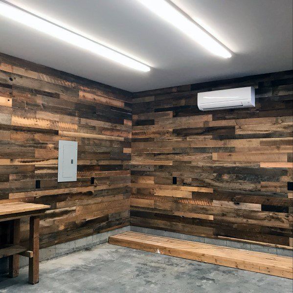 a room that has some wood on the wall and lights hanging from it's ceiling