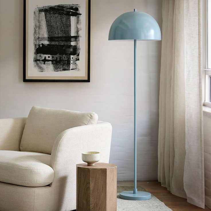 a white chair sitting next to a blue lamp in a living room