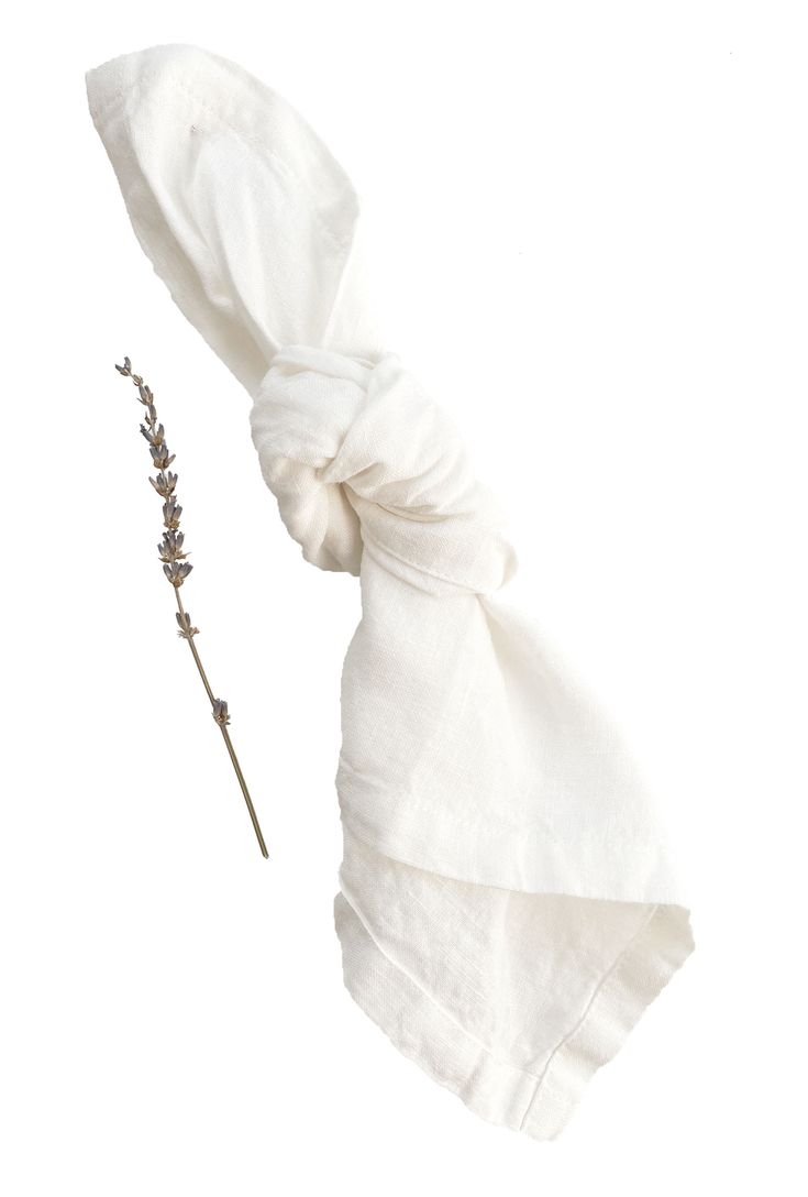 a white scarf tied to a twig on top of a headband with lavender flowers