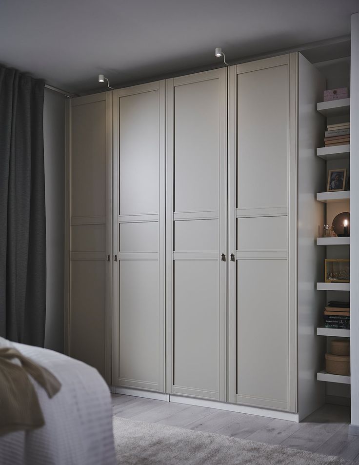 an empty bedroom with white furniture and shelving