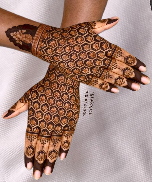 two hands with henna tattoos on them