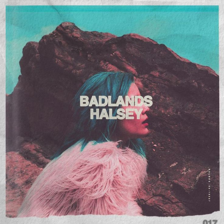 a woman with blue hair standing in front of a rock formation and the words badlands halsey over her face