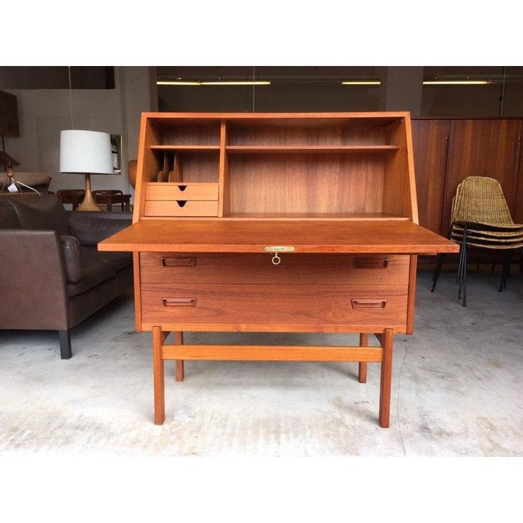 a wooden desk with two drawers and a lamp next to it in a living room