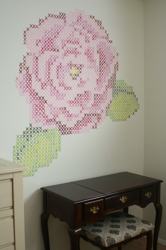 a pink flower is on the wall next to a desk