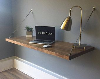 a laptop computer sitting on top of a wooden desk next to a lamp and potted plant