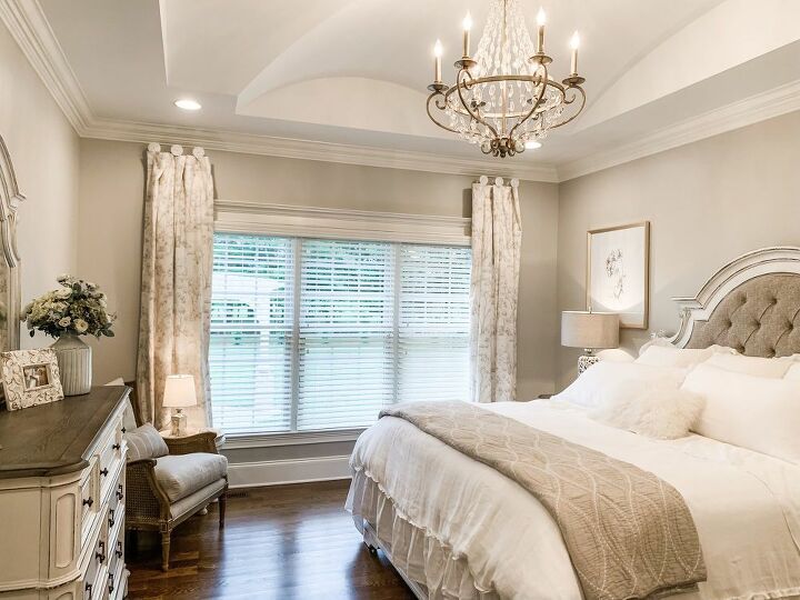 a bedroom with a chandelier and white bedding