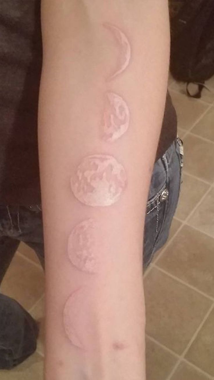 a person with a tattoo on their arm that has three circles in the shape of stars